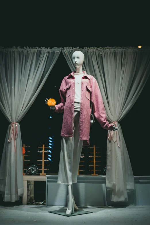 a mannequin dressed in a pink coat and white pants, trending on unsplash, inside in a glass box, blooming, with screens and silks, circa 1 9 8 4