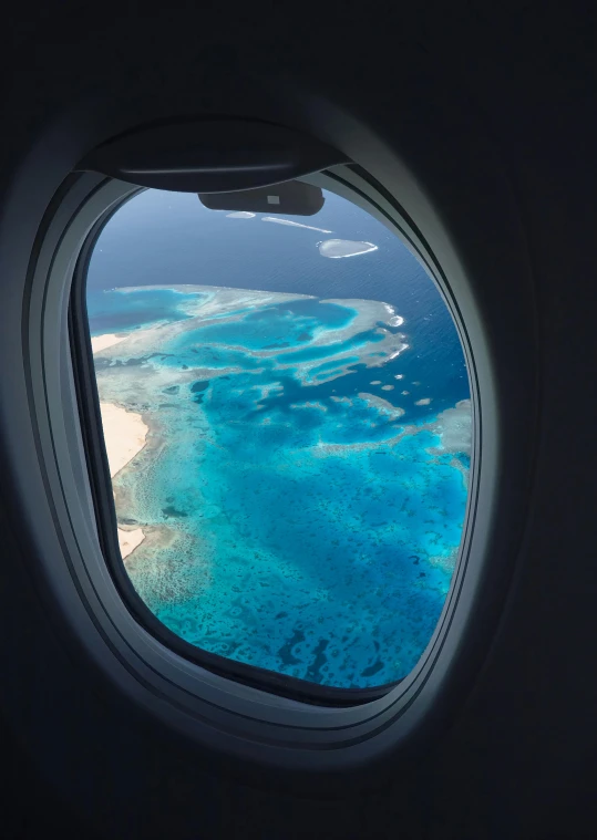 a view of the ocean from an airplane window, happening, reefs, slide show, award-winning shot, traveller