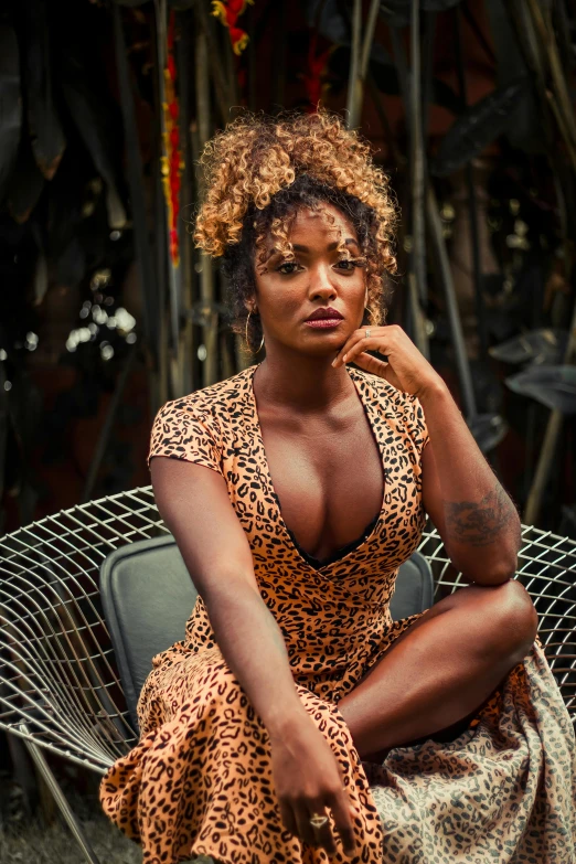 a woman in a leopard print dress sitting on a chair, trending on pexels, renaissance, afropunk, low cut dress, curly copper colored hair, media photo