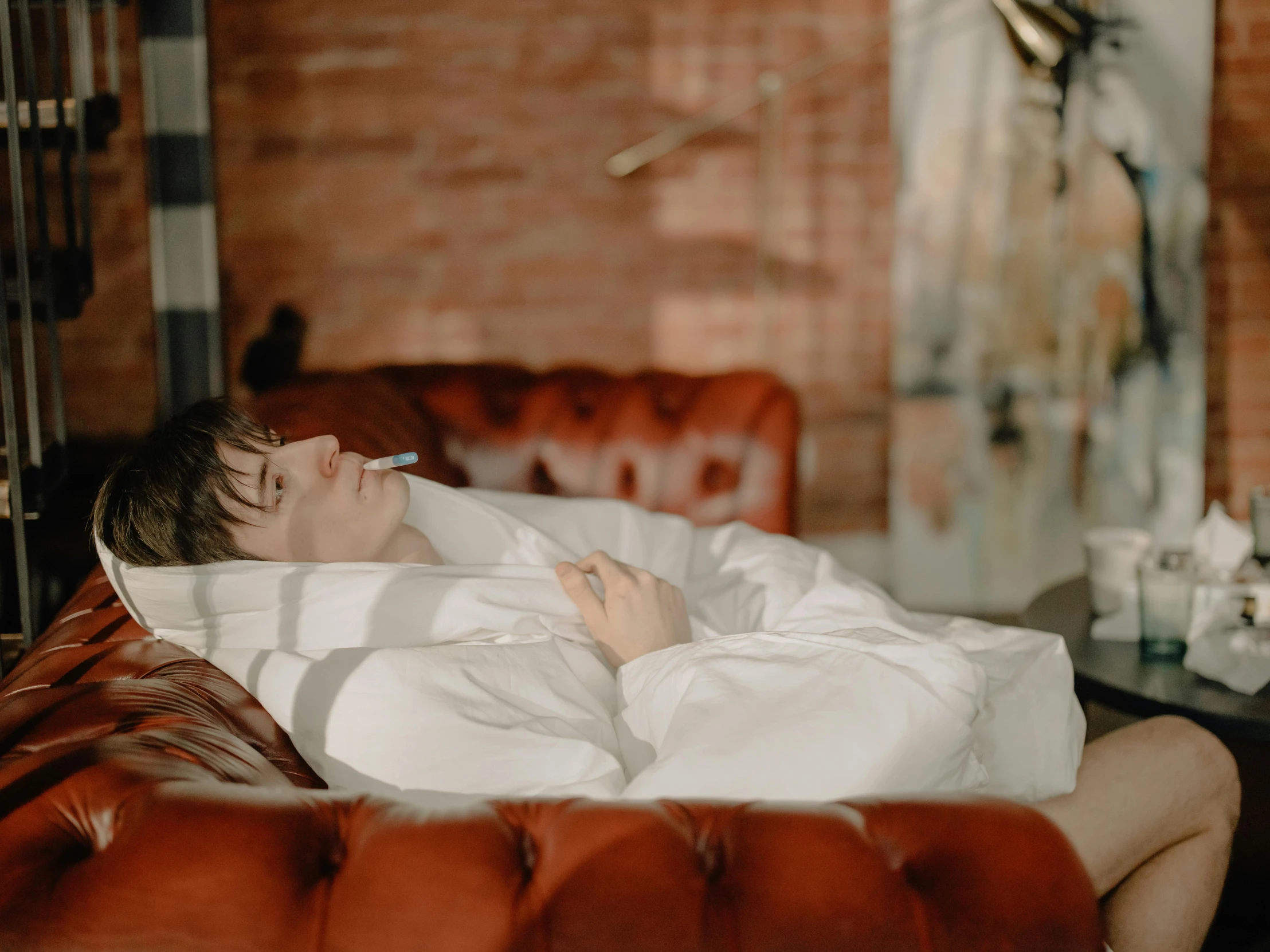 a man laying on a couch with a cigarette in his mouth, inspired by Elsa Bleda, pexels contest winner, happening, white bed, profile image, very comfy], young male with walking stick