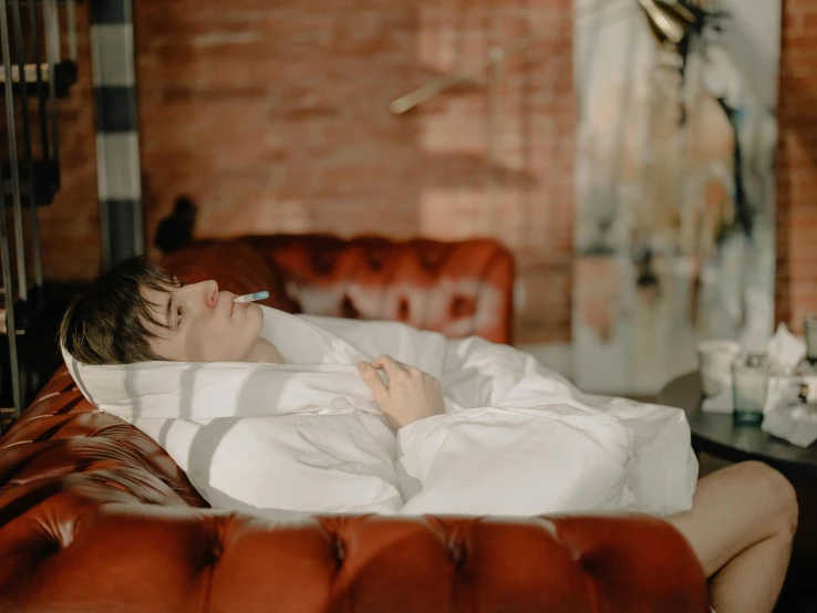 a man laying on a couch with a cigarette in his mouth, inspired by Elsa Bleda, pexels contest winner, happening, white bed, profile image, very comfy], young male with walking stick