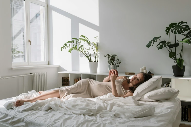 a woman laying in bed reading a book, trending on pexels, happening, full body sarcastic pose, pregnancy, city morning, photoshoot for skincare brand