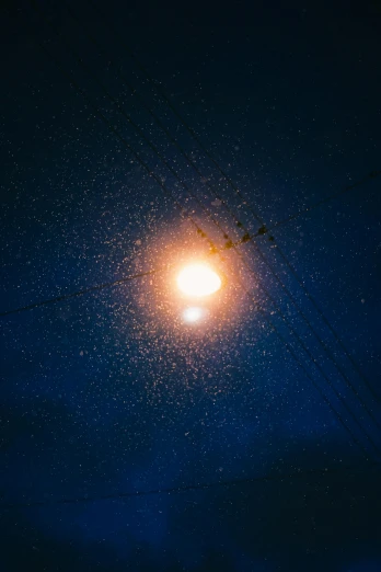 a street light shines brightly in the dark, a microscopic photo, by Attila Meszlenyi, unsplash contest winner, light and space, with two suns in the sky, starry sky 8 k, light snow, orange halo