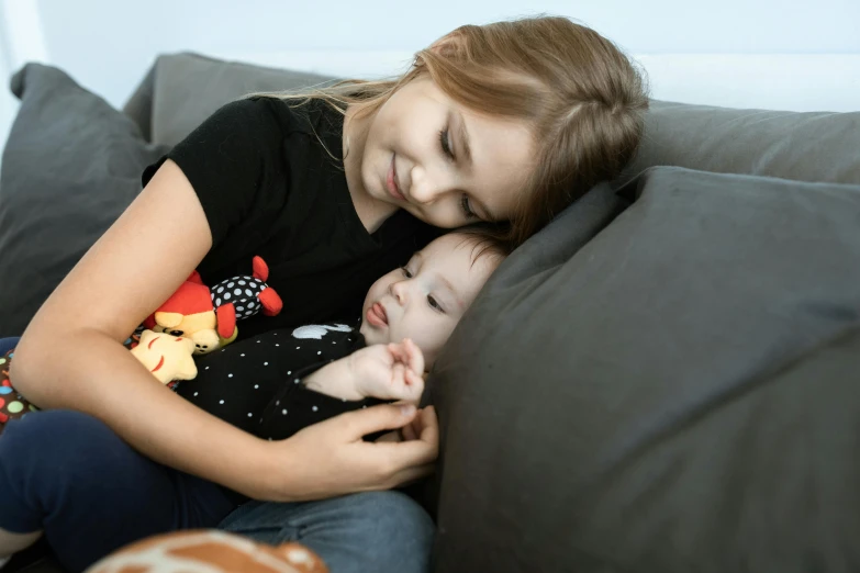 a woman holding a baby on top of a couch, pexels contest winner, girls resting, avatar image, little brother, high resolution