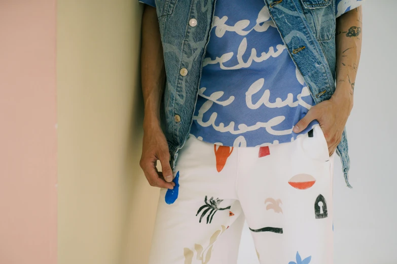 a man in a blue shirt and white pants, inspired by Tom Wesselmann, trending on pexels, graffiti, patterned clothing, pants, lots de details, printed on a cream linen t-shirt