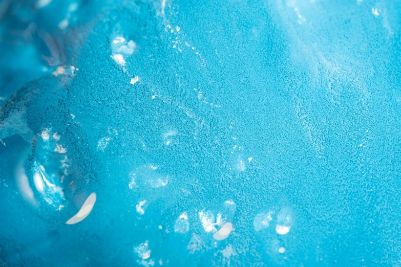 a close up of water bubbles on a blue surface, inspired by Lynda Benglis, trending on unsplash, process art, sitting on top of a cryopod, covered in white flour, sea of parfait, made of glowing wax