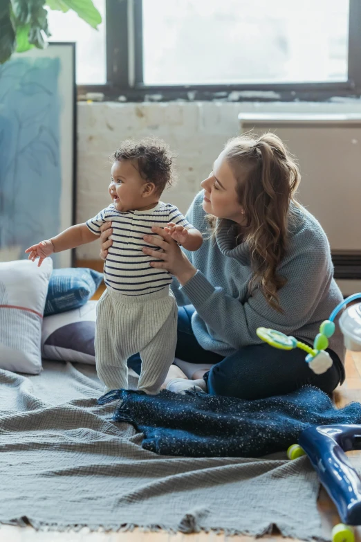 a woman sitting on the floor playing with a baby, zellk, strong presense, inside a child's bedroom, feels good man