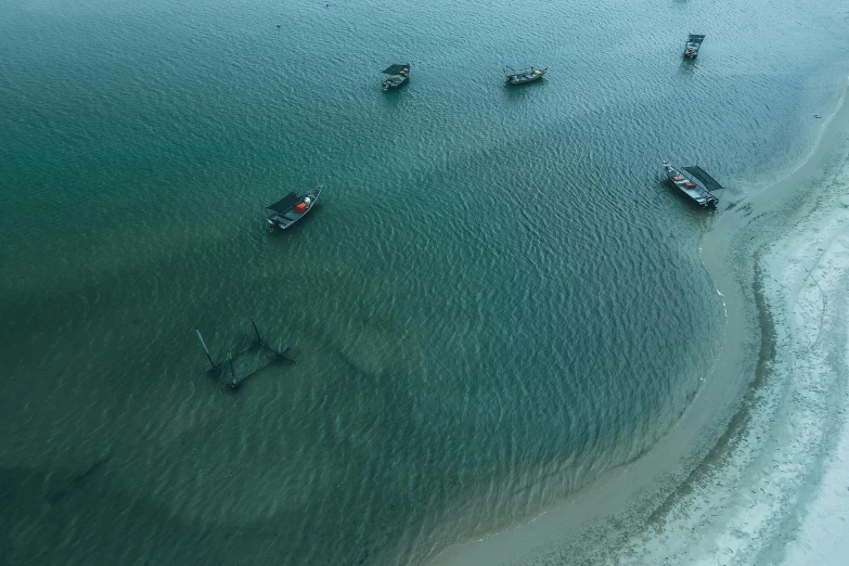 a group of boats floating on top of a body of water, by Peter Churcher, pexels contest winner, hurufiyya, dredged seabed, air shot, ash thorp, beached submarine