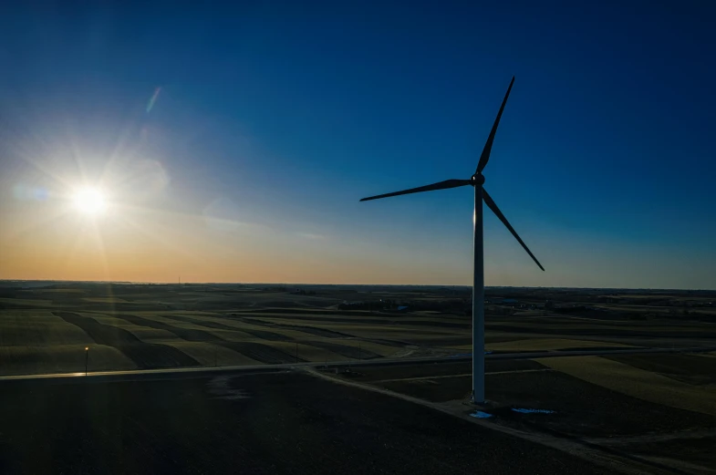 a wind turbine in the middle of a field, by Jesper Knudsen, pexels contest winner, late afternoon sun, aerial footage, profile picture 1024px, high-quality photo