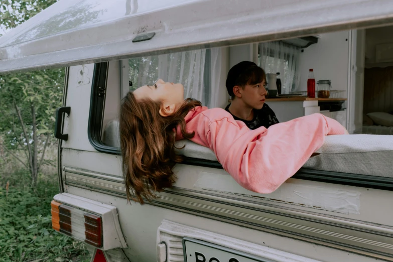 a little girl sticking her head out the window of a camper, a photo, by Emma Andijewska, trending on pexels, realism, belle delphine, pink, two models in the frame, cai xukun
