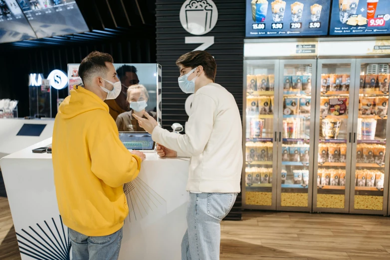 a couple of men standing in front of a counter, pexels, interactive art, surgical mask covering mouth, ice cream on the side, electronic case display, avatar image