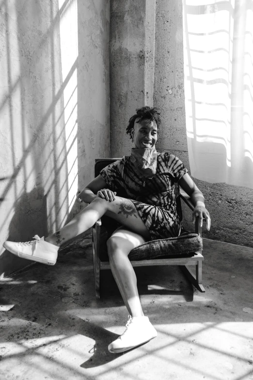 a black and white photo of a man sitting in a chair, inspired by Billie Waters, fluxus, in a prison cell, in the sun, 2 1 savage, madly grinning