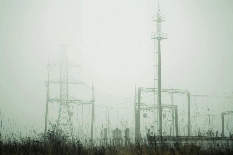 a group of power lines on a foggy day, a portrait, by Adam Marczyński, industrial photography, grey, a green