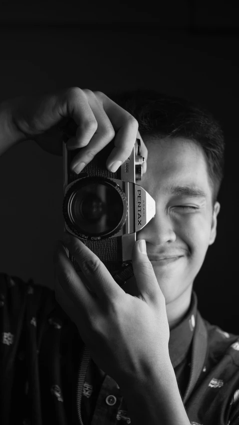 a man taking a picture with a camera, a black and white photo, inspired by Rudy Siswanto, smiling for the camera, avatar image, uploaded, professional profile photo