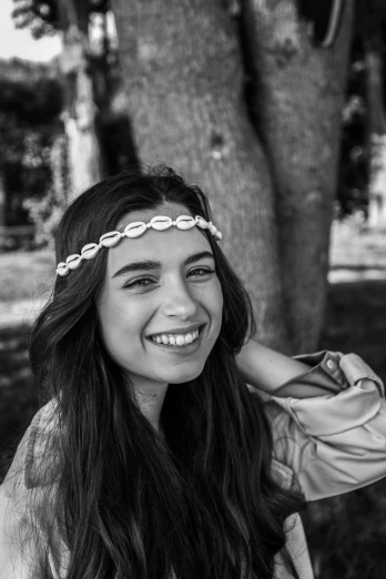 a black and white photo of a woman smiling, a black and white photo, by Altichiero, wearing seashell attire, smiling girl, wearing a headband, ana de armas