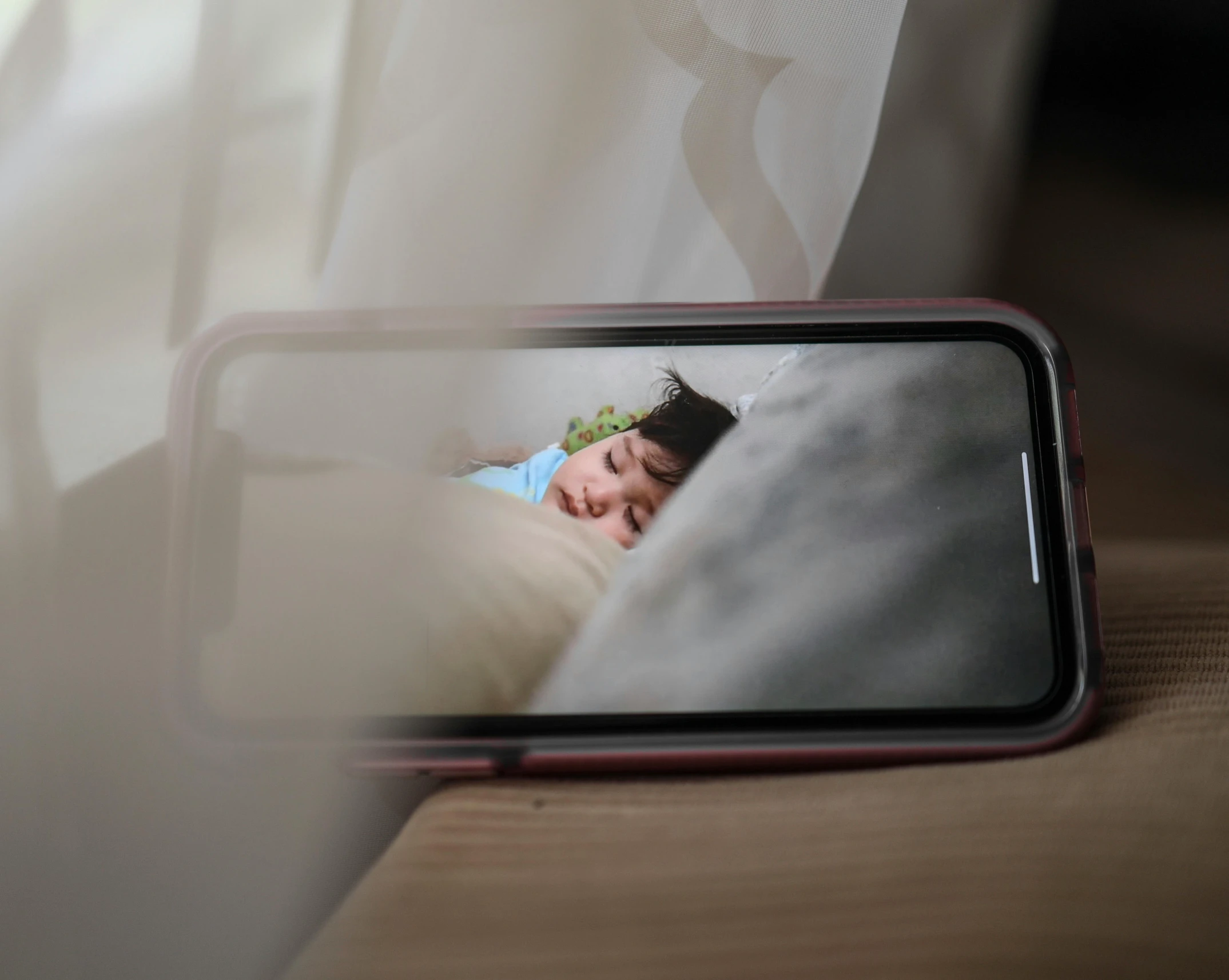 a cell phone sitting on top of a wooden table, a picture, by Julia Pishtar, trending on pexels, happening, someone sits in bed, dreaming face, 8 k photo, picture through the screen