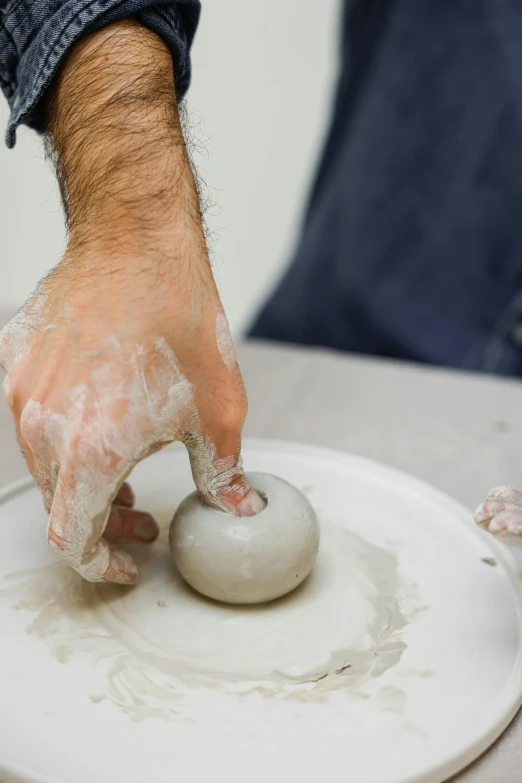 a close up of a person making something on a plate, a marble sculpture, inspired by Hendrik Gerritsz Pot, donut, up to the elbow, ash thorp, ready to model