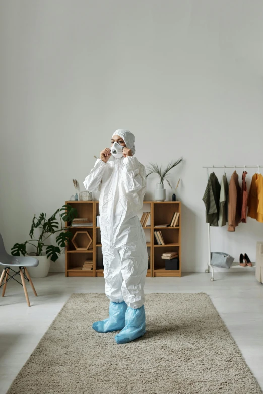 a man in a protective suit talking on a cell phone, an album cover, pexels contest winner, rugs, full body 8k, at home, white puffy outfit