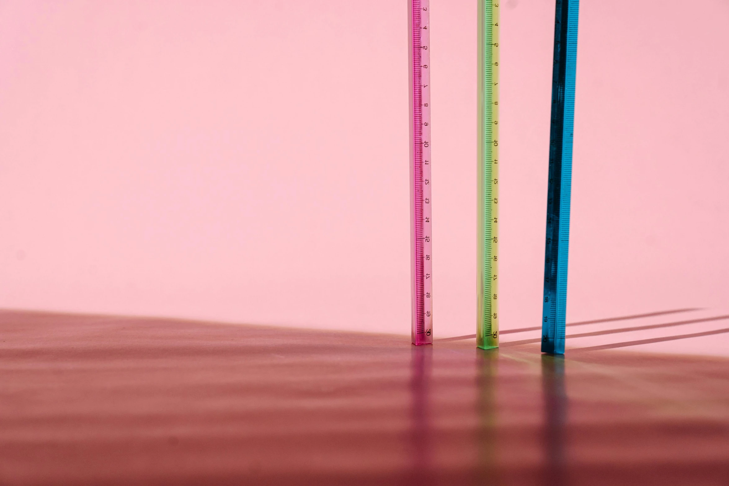 a stack of plastic straws sitting on top of a wooden floor, unsplash, analytical art, brightly lit pink room, reflective scales, glass obelisks, measurements