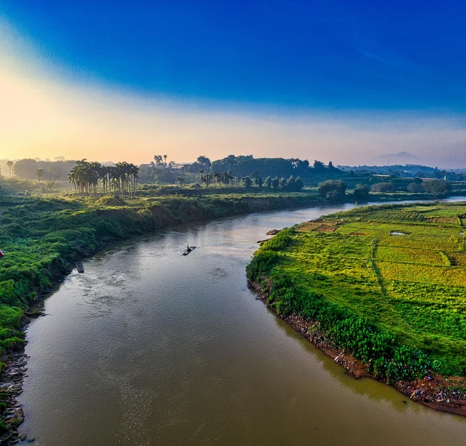 a river running through a lush green field, by Sudip Roy, pexels contest winner, panoramic view, morning hard light, bangladesh, slide show