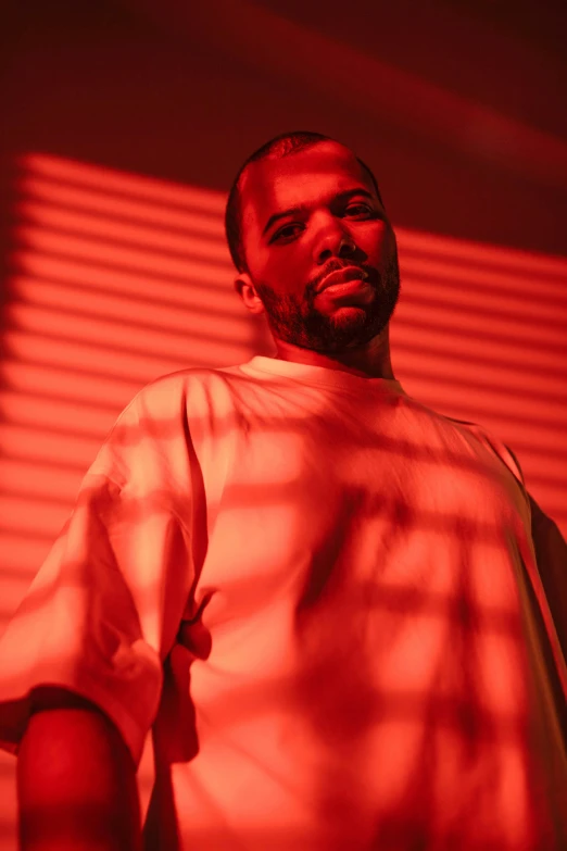 a man standing in front of a red light, ice cube, frank ocean, seductive expression, dolman