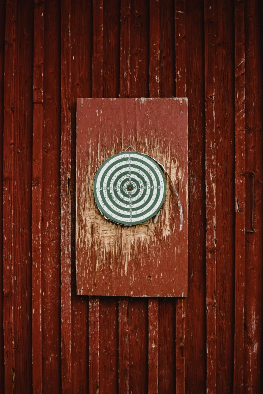 a red door with a spiral design on it, a picture, by Svend Rasmussen Svendsen, target reticles, on wood, barn, promo image