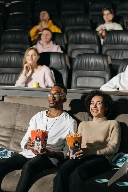 a group of people sitting on a couch watching a movie, square, high-quality photo, maximus jacobs, couple