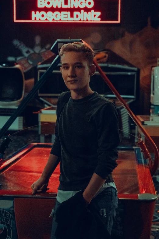 a boy standing in front of a pool table, justin sun, bo burnham, hollywood promotional image, animatronic mark zuckerberg