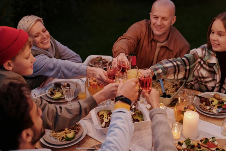 a group of people sitting around a dinner table, holding a glass of wine, food. craft and adventure, profile image, gardening