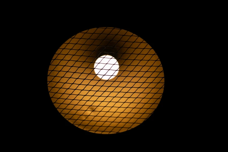 a close up of a light in a dark room, an album cover, flickr, computer art, there is a loose wire mesh, yellowish full moon, street lighting, round design