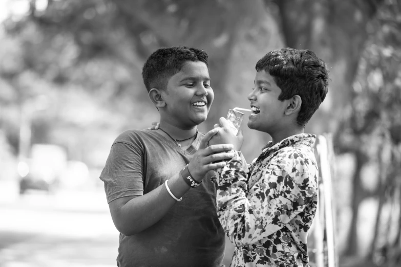 a couple of men standing next to each other, a black and white photo, by Max Dauthendey, pexels, samikshavad, happy kid, drink milkshakes together, expressing joy. by krenz cushart, photographic print