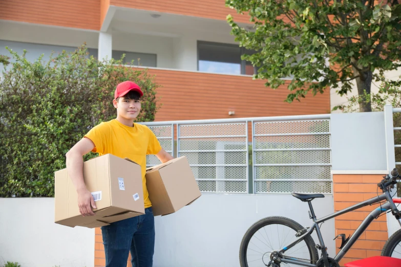 a man holding two boxes while standing next to a bike, profile image, portrait image, small, image