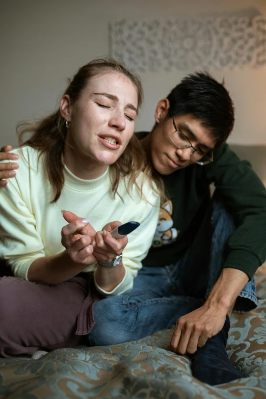 a couple of people sitting on top of a bed, trending on reddit, antipodeans, crying and reaching with her arm, high resolution photo, lgbtq, holding a small vape