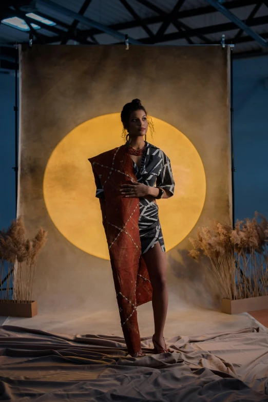 a woman standing in front of a backdrop holding a surfboard, by Olivia Peguero, conceptual art, under the moon, masai, at a fashion shoot, holding a shield