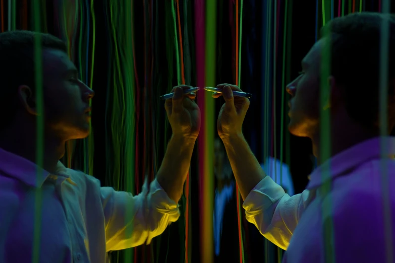 a couple of men standing next to each other in front of a mirror, inspired by Bruce Munro, pexels contest winner, interactive art, colorful wires, still from the movie ex machina, holding a magic needle, teamlab