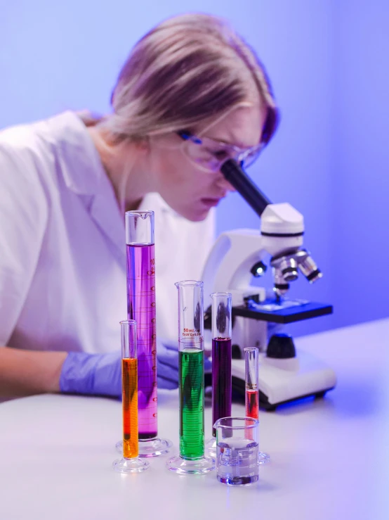 a woman in a lab coat looking through a microscope, trending on pexels, analytical art, lava lamps, purple, inspect in inventory image, wearing an academic gown