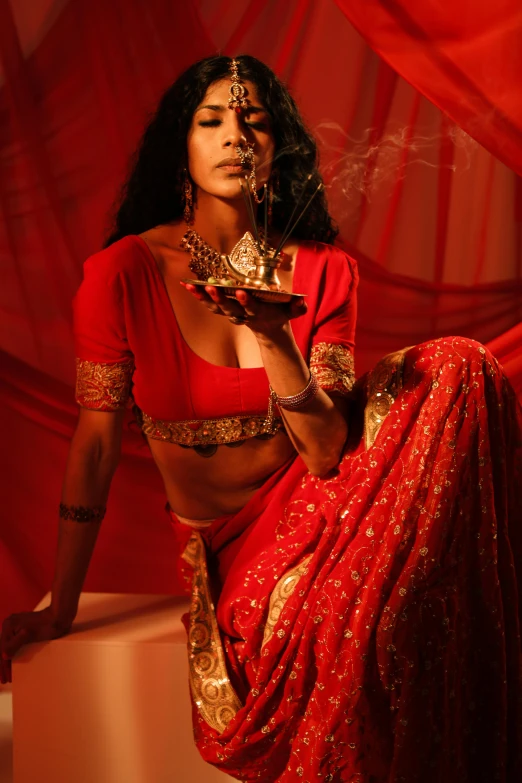 a woman in a red sari smoking a cigarette, an album cover, pexels contest winner, renaissance, cinematic outfit photo, sza, exotic costumes, ( ( theatrical ) )