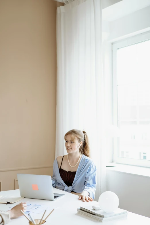 a couple of people sitting at a table with laptops, by Carey Morris, trending on pexels, renaissance, young woman looking up, standing in corner of room, slightly minimal, portrait of sanna marin