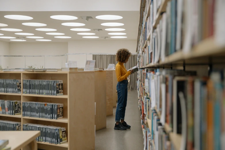 a little girl that is standing in a library, pexels contest winner, light and space, sustainable materials, shelf, profile image, non-binary