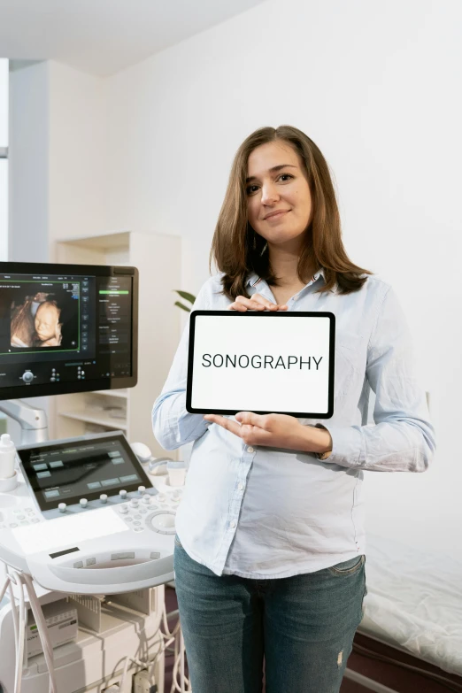 a woman holding a sign in front of a computer, inspired by Jens Søndergaard, unsplash contest winner, holography, medical photography, topography, pregnancy, on an operating table