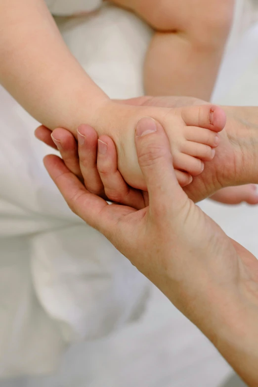 a close up of a person holding a baby's hand, acupuncture treatment, square, barefoot, nanae kawahara