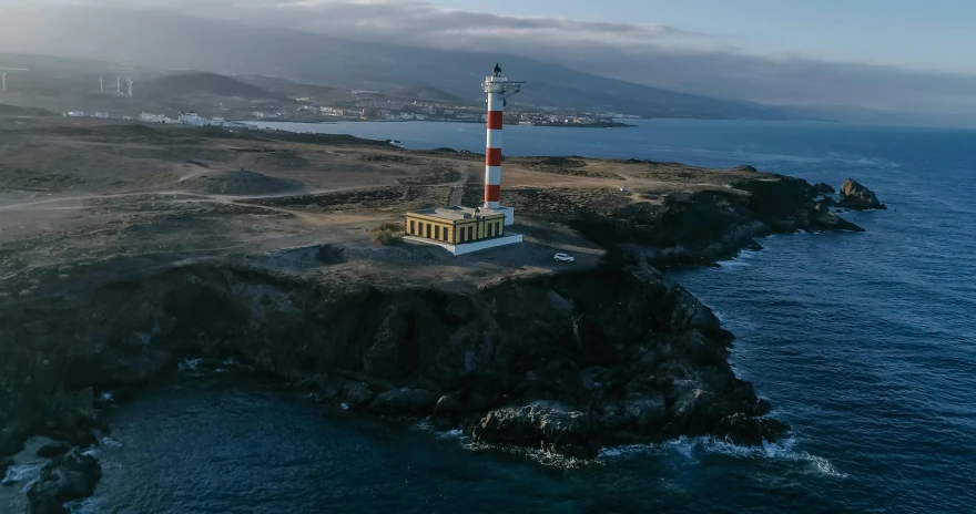 a lighthouse sitting on top of a cliff next to the ocean, square, islandpunk, lit from above, spanish