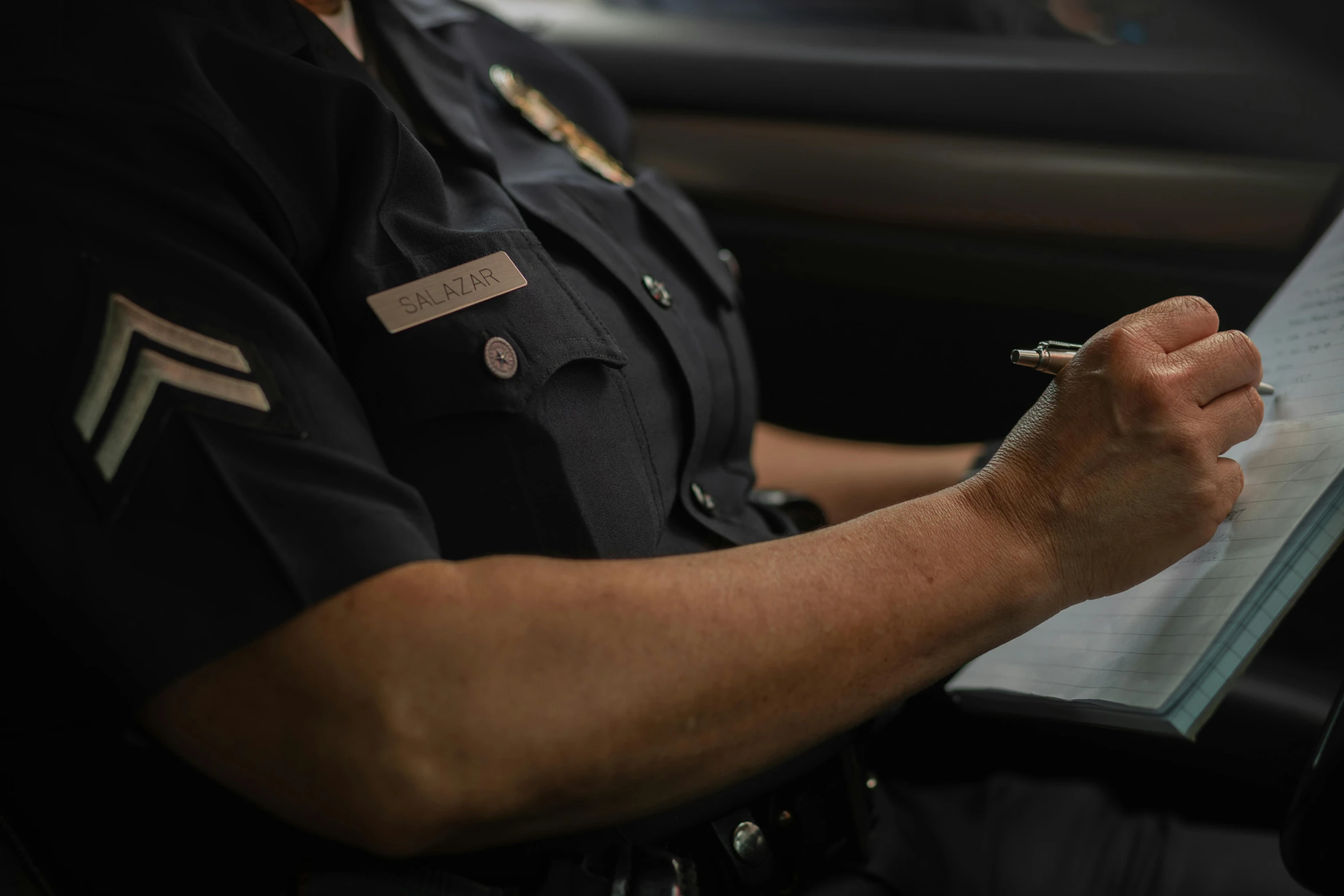 a police officer writing on a piece of paper, unsplash, promo image, alana fletcher, multiple stories, service ticket close up