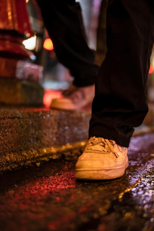 a person standing on a sidewalk next to a fire hydrant, by Matt Stewart, renaissance, gum rubber outsole, nightlife, dirt stains, in a row