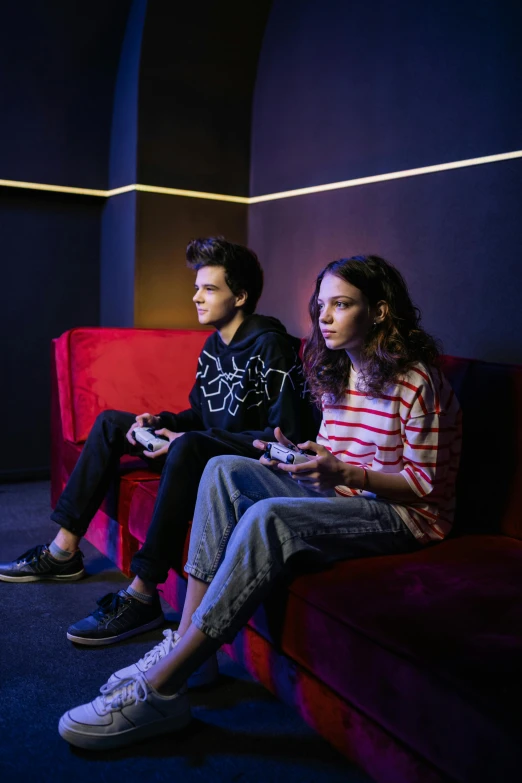 two people sitting on a couch playing a video game, antipodeans, dafne keen, teenager hangout spot, studio lit, promo image