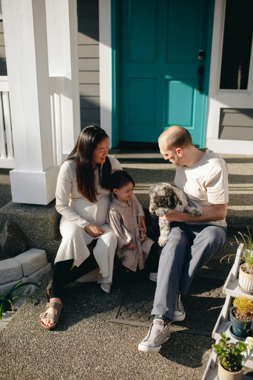 a man and woman sitting on the steps of a house with a dog, tyler edlin and natasha tan, husband wife and son, ballard, with tiny people