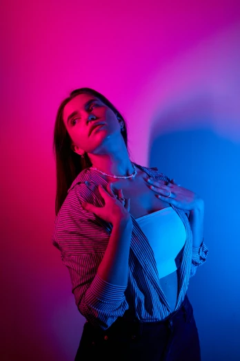 a woman standing in front of a pink and blue background, an album cover, inspired by Elsa Bleda, unsplash, blue and red lights, model shoot, 5 0 0 px models, bisexual lighting