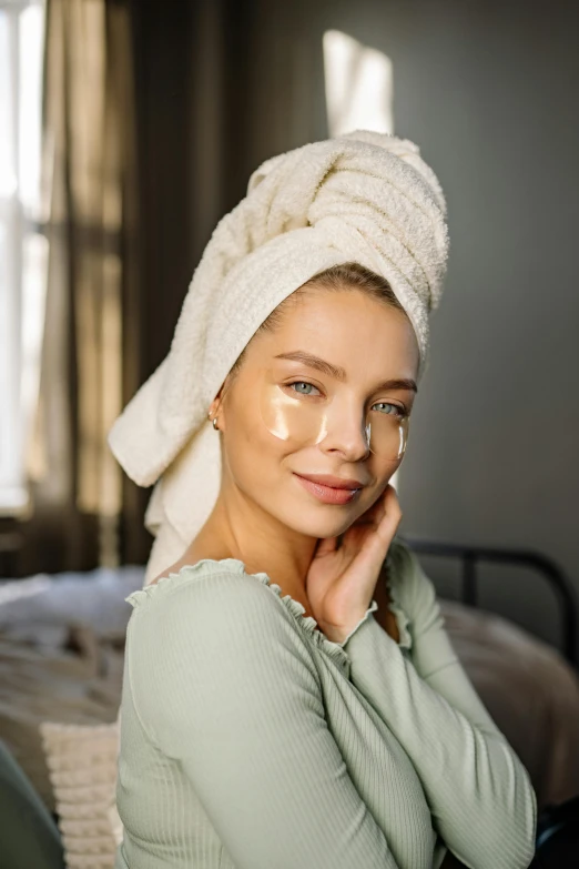 a woman sitting on a bed with a towel on her head, a picture, by Julia Pishtar, trending on pexels, renaissance, beauty mark on cheek, silicone skin, blending, morning glow