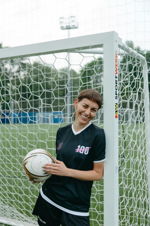 a woman holding a soccer ball in front of a goal, a portrait, inspired by Ion Andreescu, unsplash, smiling, low quality photo, sergey krasovskiy, various posed