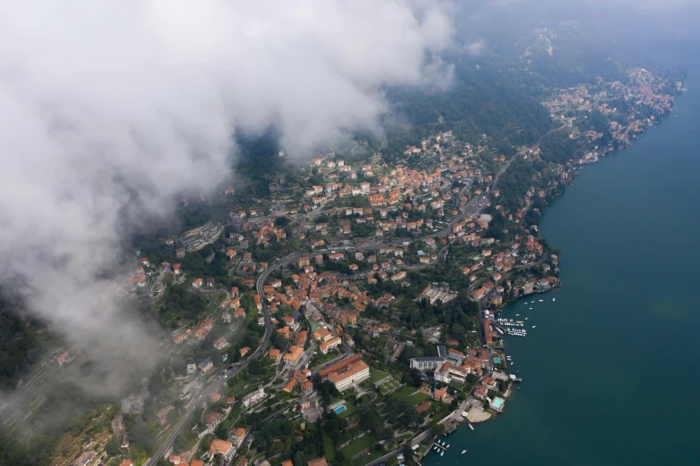 an aerial view of a city next to a body of water, by Daniel Lieske, pexels contest winner, renaissance, covered in clouds, boka, abbondio stazio, thumbnail